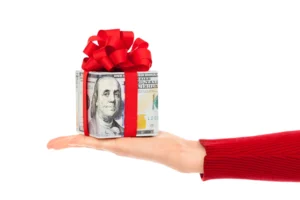 Hand holding gift-wrapped bundle of cash